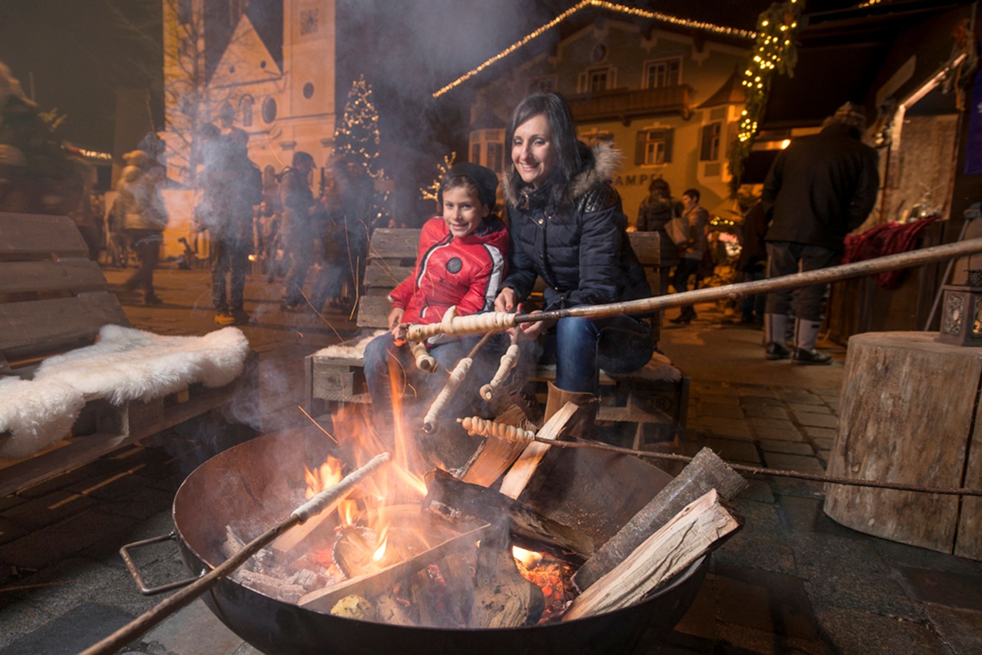 Family cooking food over the fire at St Johann Christmas market