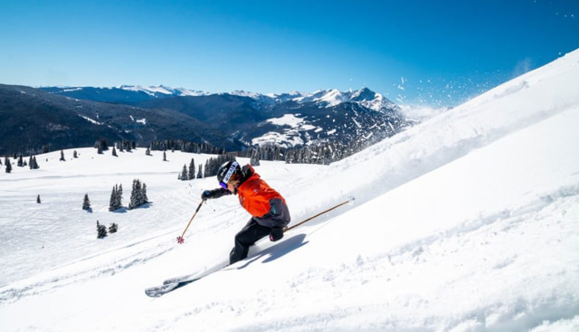 Skier going down a slope on a sunny day