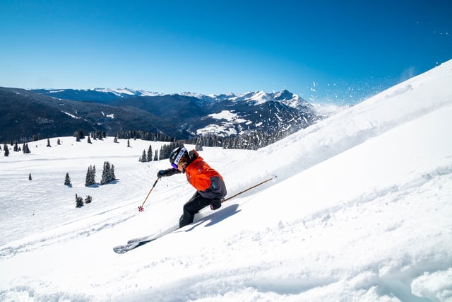 Skiing going down a slope on a sunny day