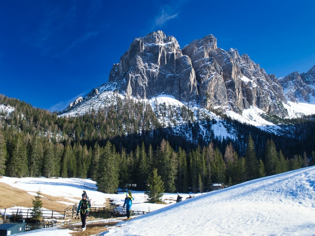 Group of skiers walking with their skis up a mountain in the Dolomites
