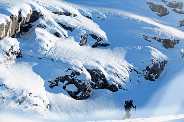 A solo man skier ski touring through the mountains in Chamonix