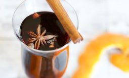 Close up of a glass of mulled wine with a star of cloves sitting at the top of the drink