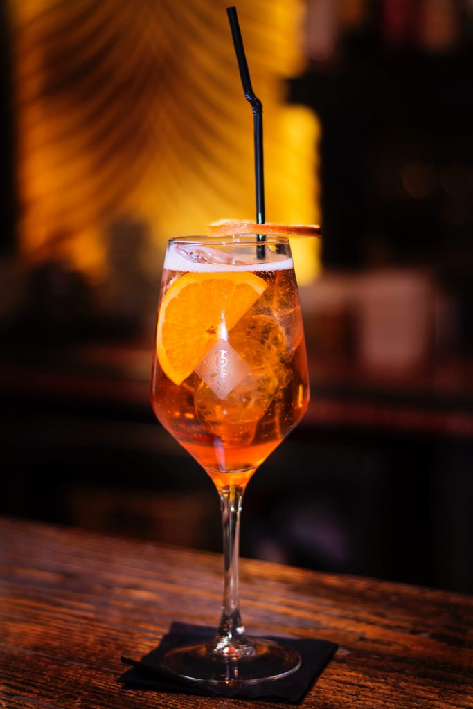 An aperol cocktail on the side of a bar