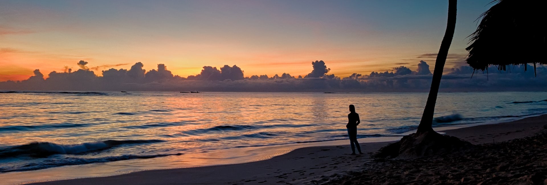 Person standing on a tropical beach watching the sunset in Punta Cana
