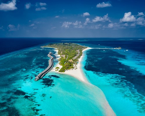 Aerial view small tropical island with white sand beaches and over water villas