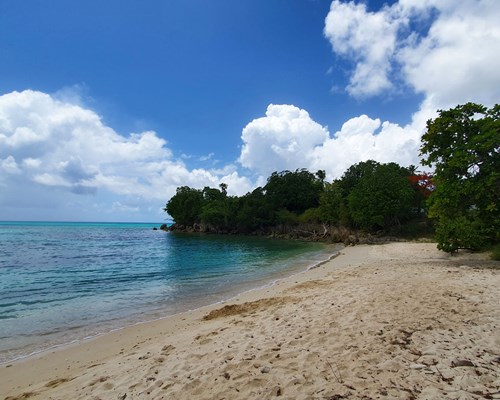 A natural, unspoiled tropical beach with turquoise sea and white sand beach