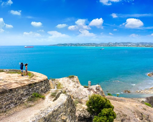 2 people standing on top of Fort Barrington overlooking the sea