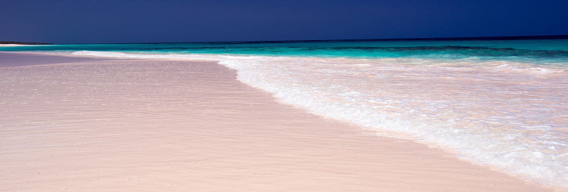 Waves crashing on a pink sand beach