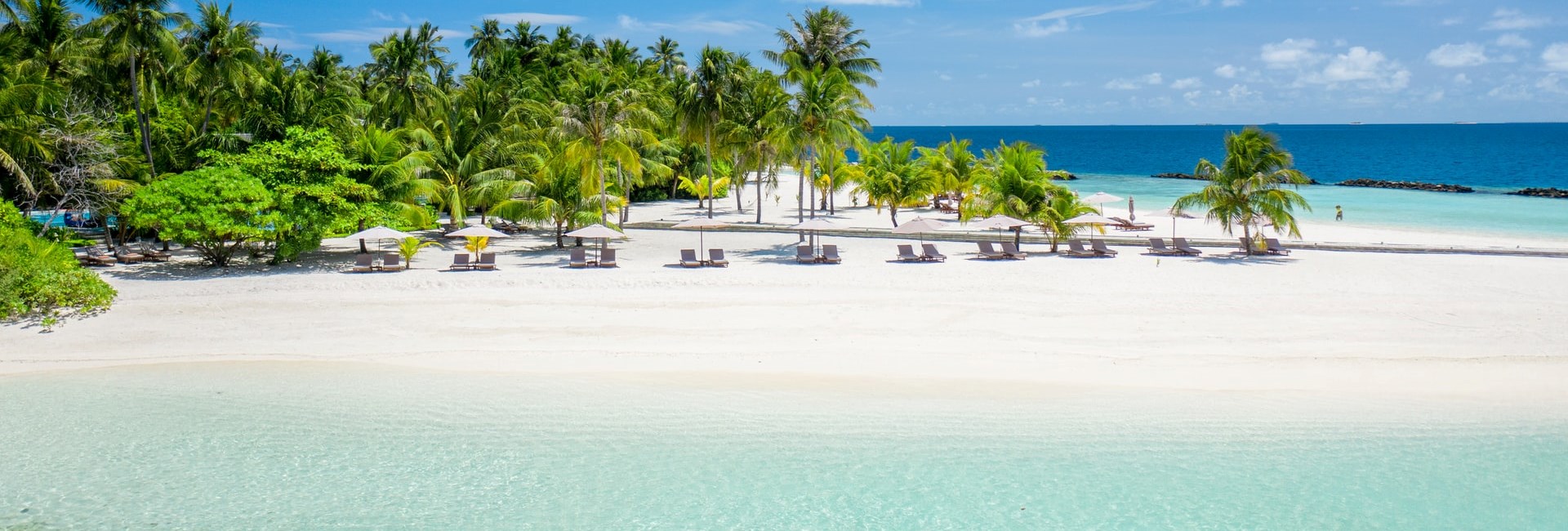 Sun loungers out on a small beach on a tropical island
