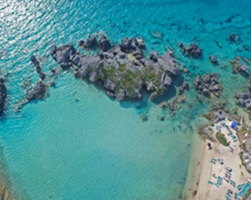 Aerial view of Tobacco bay, rocky sea and people settled on the beach