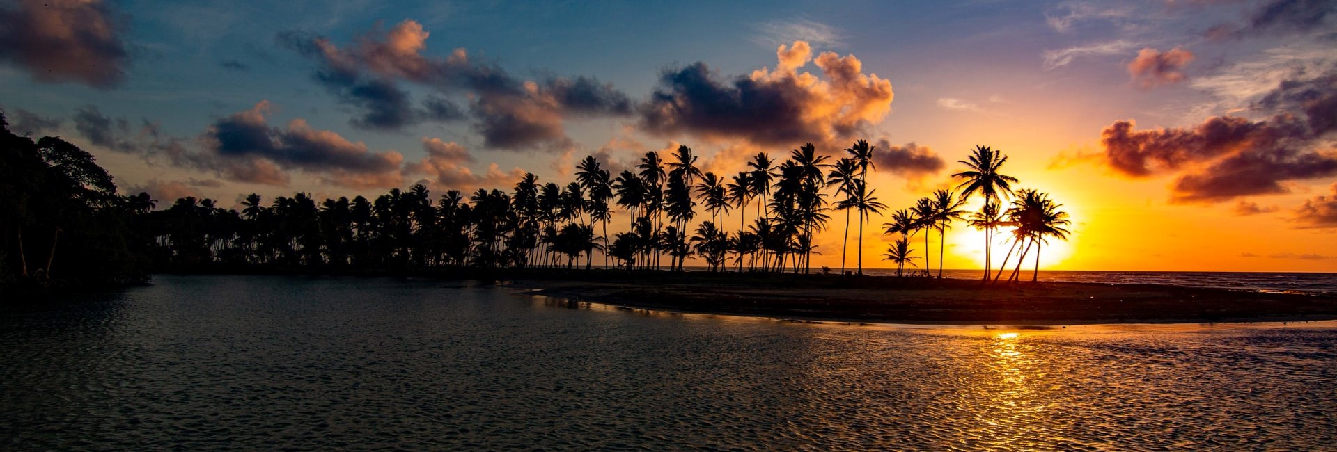 Sunset behind palm trees on a tropical beach