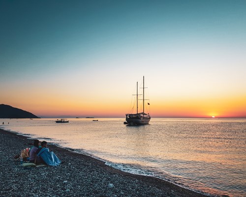 Two people watching a boat on Cirali Beach
