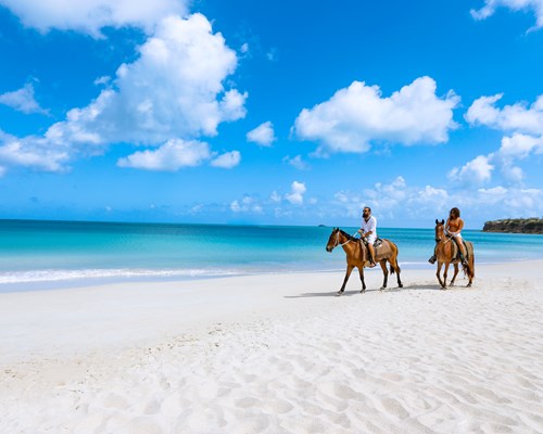 2 people horse riding on Fort James Beach in Antigua