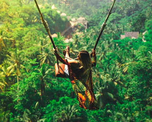 Woman enjoying a swing in a rainforest