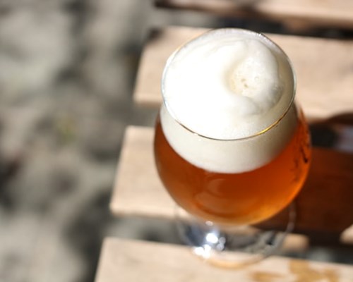 Close up of glass of beer on wooden table