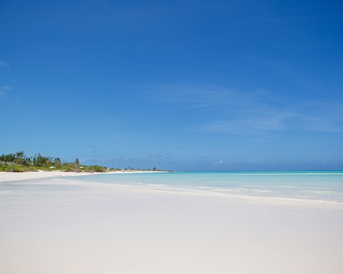 Wide white sand beach with calm bright blue sea 