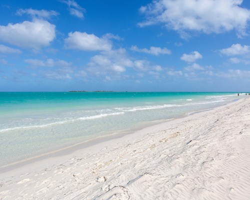 Picturesque long white sand beach lapped by clear blue calm water