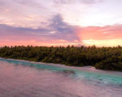 Pink sunset sky over a tropical island in the Maldives