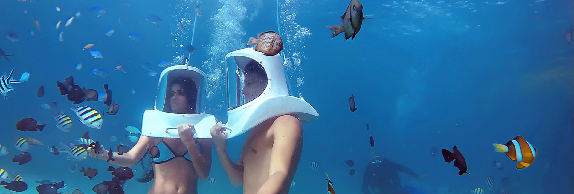 Couple Helmet Diving In Clear Blue Carribean Sea With Tropical Fish