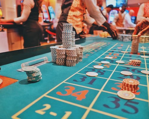 Dealer Spinning Wheel Of Roulette Table In Casino