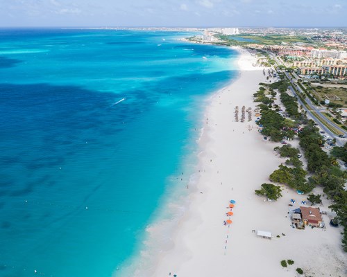 Aerial view of long and narrow white sand beach and clear blue sea