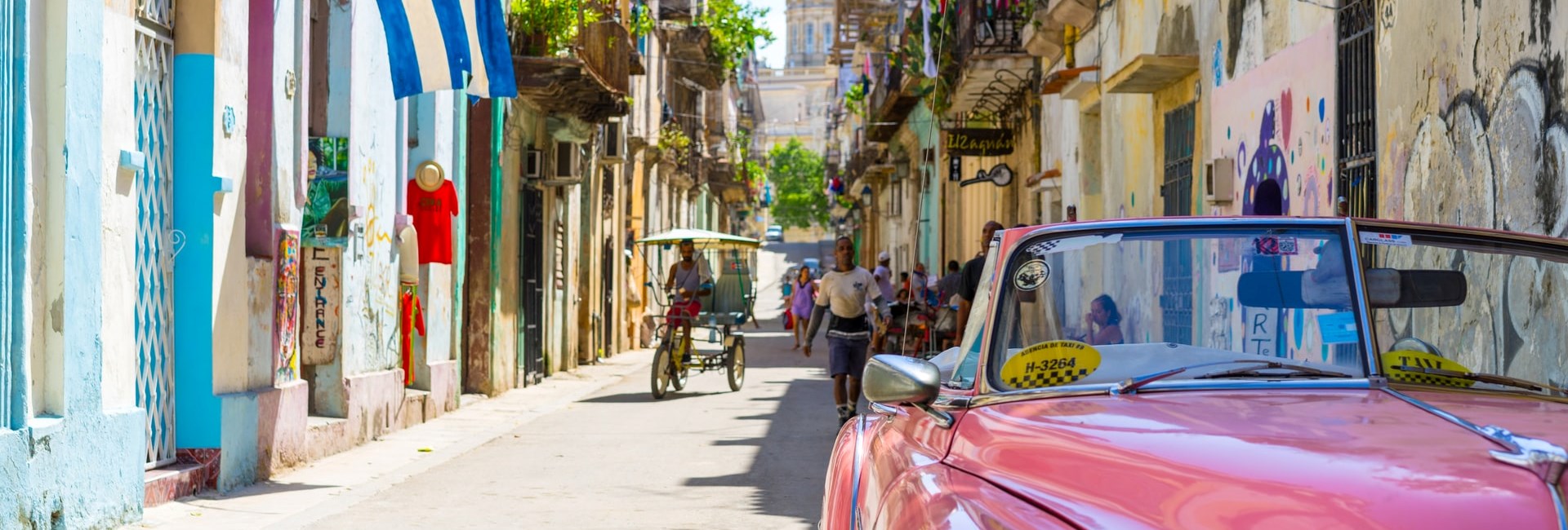 Pink convertible car parked on a quiet residential street in Havana 
