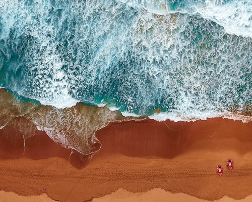 Red sands contrasting with the deep blue sea waves
