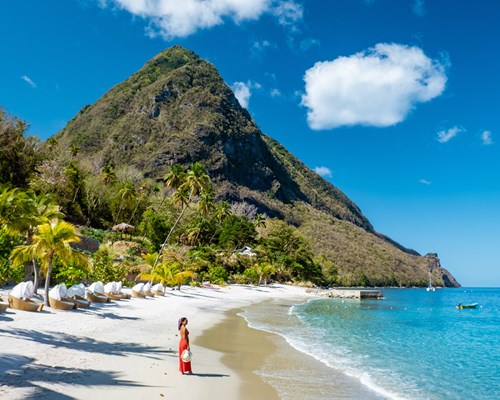 Woman walking on the beach with red dress in St Lucia