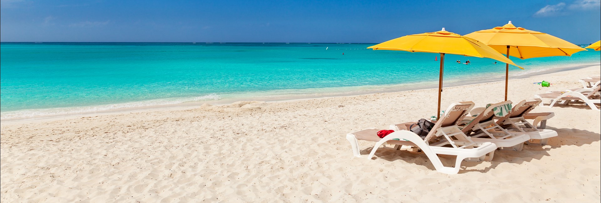 White deckchairs with yellow sun umbrellas on Grace Bay