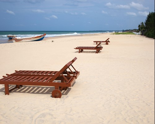 Wooden sun loungers on a white sand beach