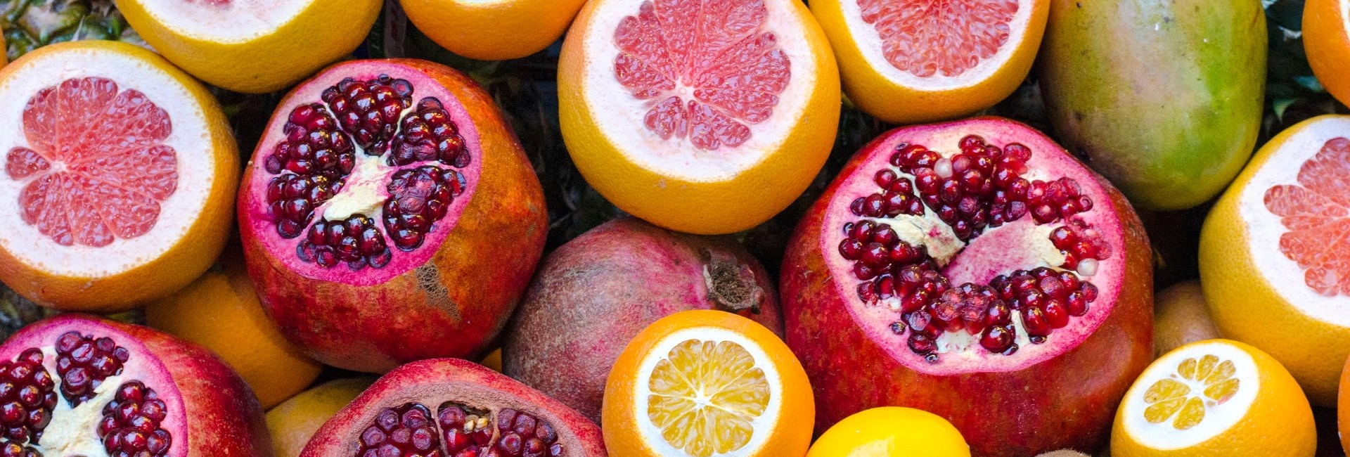 Close up of halved pomegranates, oranges and lemons