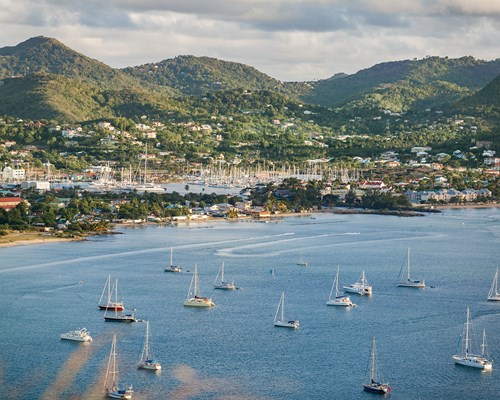 Sailing yachts anchored in bay of a mountainous tropical island