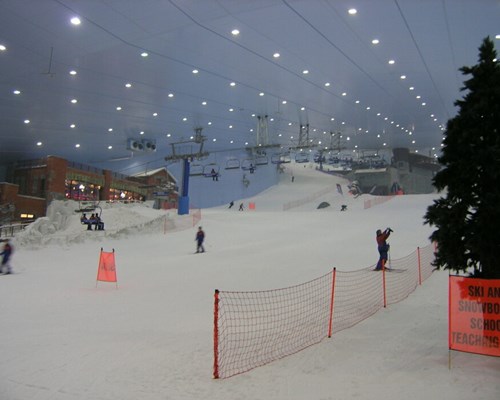 People skiing in a large indoor ski dome 