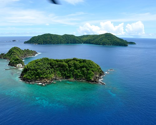 Aerial view of several small hilly islands surround by clear blue water