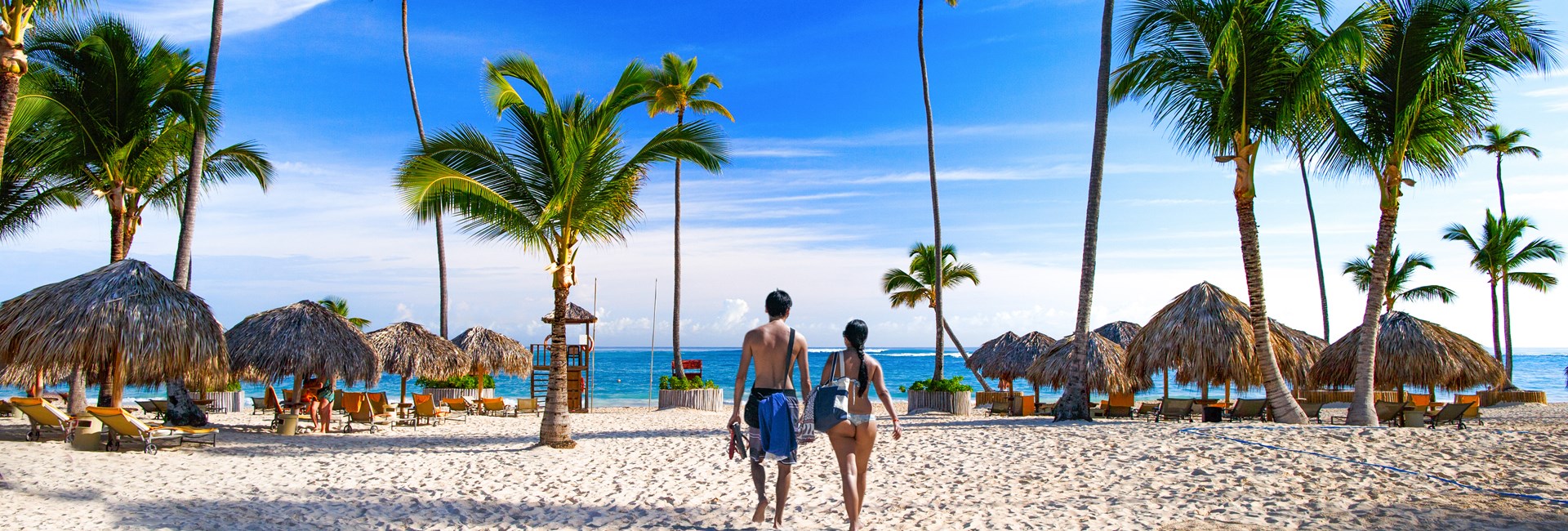 Couple walking across white sand Bavaro Beach in Punta Cana
