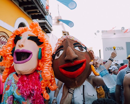 Two people happily loving San Sebastian street festival wearing masks