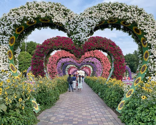 Couples walking through a heart shaped flower garden