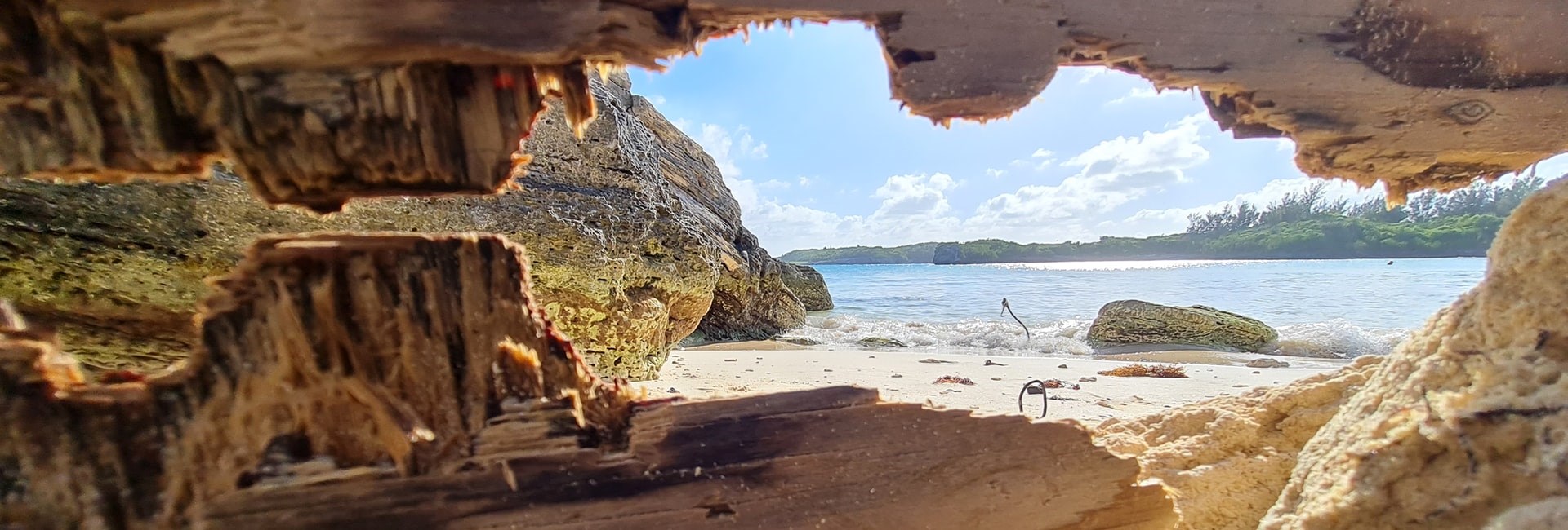 View of tropical beach and sea from the inside of a cave with jagged rock formations