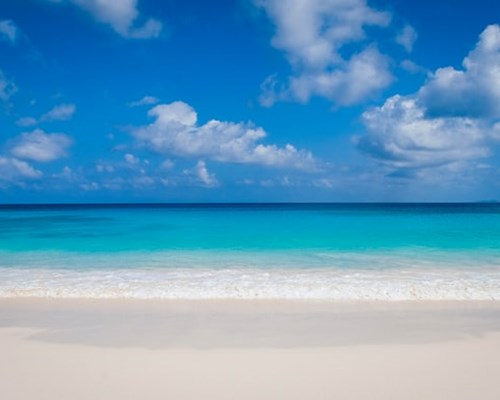 Calm turquoise sea with white beach