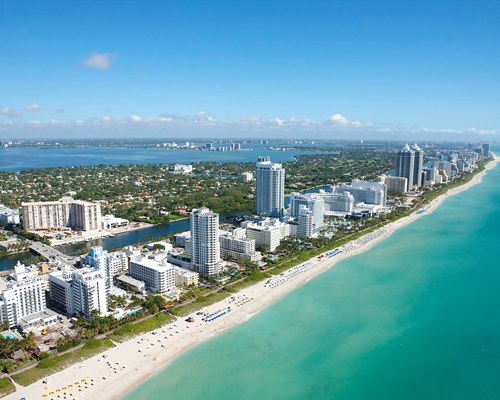 A long strip of Miami Beach fringed by resorts and buildings