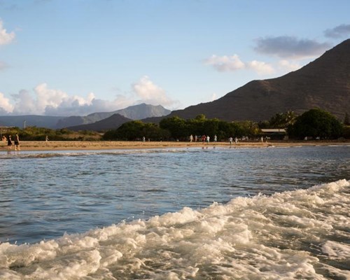 Landscape photo of mountains in the background of a beige beach