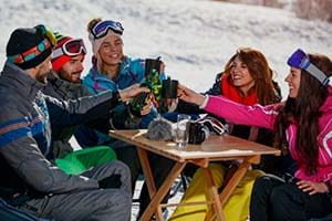 A group of friends drinking outside a ski bar